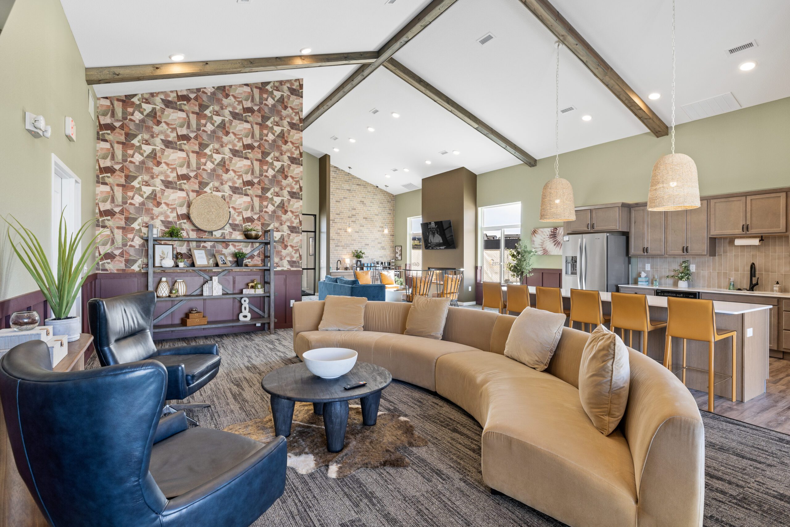 Community room interior at 10 Bedrock Apartments in Rapid City, South Dakota where Great States Construction served as general contractor, featuring vaulted ceilings, kitchen island, and lounge seating