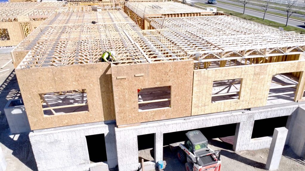 A worker sets floor joists at the Village Cooperative in Billings, Montana