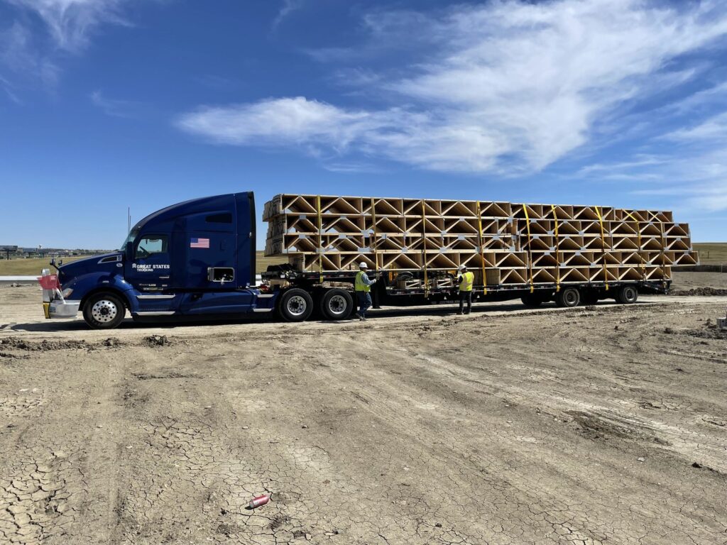 Semi truck delivering roof trusses to the 10Bedrock Apartments site in Box Elder, South Dakota