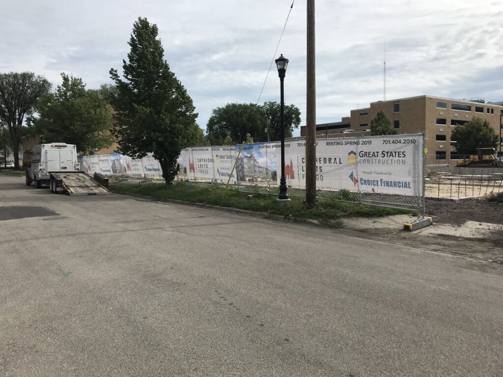 Construction fence with Great States Construction signage at the Cathedral Lofts site in downtown Fargo