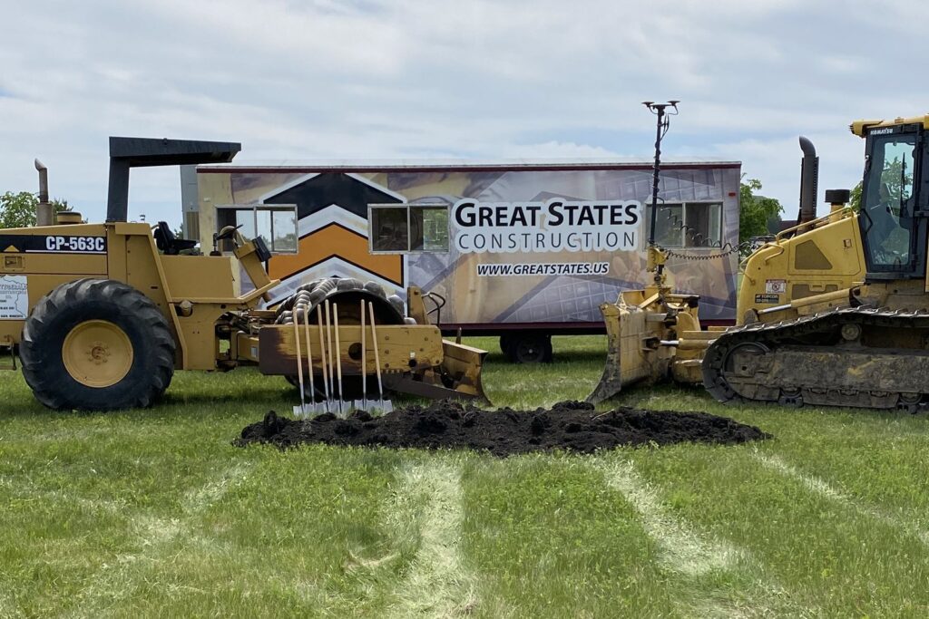 Groundbreaking shovels and equipment in front of a Great States Construction job site trailer