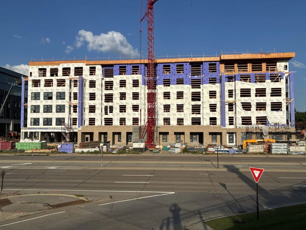 The Setting on France framed and wrapped six stories high with a crane on site in Edina, Minnesota